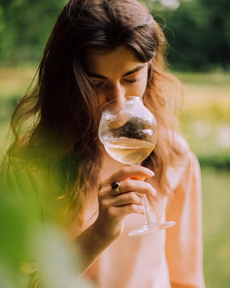 Mujer oliendo una copa de vino durante la cata guiada